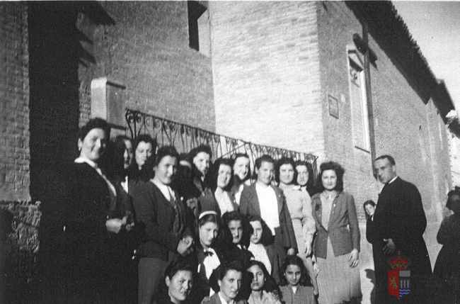 Grupo de jóvenes en la puerta de la iglesia. La Puebla de Alfindén