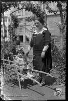 Mujer con niña sobre un carro de juguete. Joaquín Galán Bernal