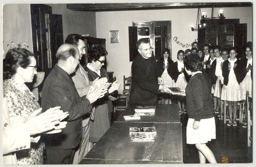 Cultura. Juventudes femeninas. Fiesta de santa Teresa de Jesús, patrona de la Sección Femenina. Entrega de libros por Jerónimo Beltrán Burriel en presencia de Ulpiano González Medina, gobernador civil de la provincia, Rita Navarro Mínguez, delegada provincial de la Sección Femenina, subdelegada provincial y camarada Carmen Salomón, en el albergue de juventudes Rosa Bríos. Albarracín