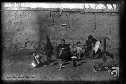 Dos hombres y un niño con paraguas, cacerolas y juguetes. Joaquín Galán Bernal. Huesca