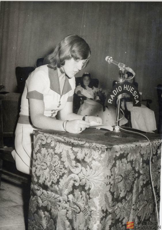 Niña leyendo para la emisora de Radio Huesca