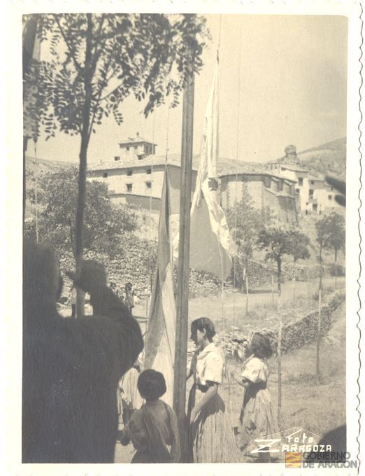 Inauguración del albergue de juventudes Rosa Bríos. Flechas en el acto de izar banderas. Al fondo el antiguo hospital y la ermita de San Juan. Foto Zaragoza. Albarracín
