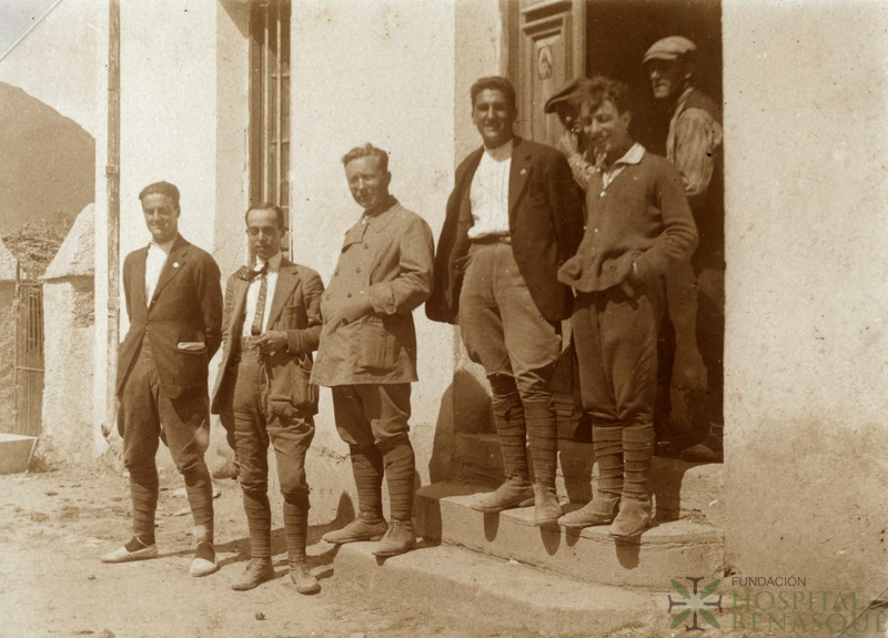 Siete personas delante de una puerta en un pueblo del valle de Arán