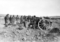 Pieza de 105 mm. de artillería nacional haciendo fuego. Grupo de requetés observando. Antonio Cobos Berges