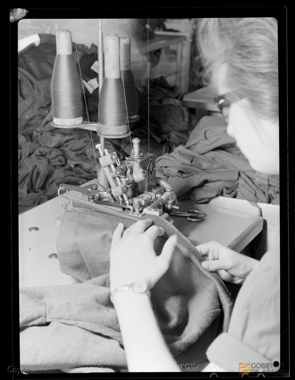 Interior fábrica. Maquinaria. Industria textil. Corte y confección. Telas. Máquina de coser. trabajadora