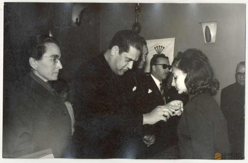 Cultura. Juventudes femeninas. Fiesta de Santa Teresa de Jesús, patrona de la Sección Femenina. Acto de imposición de insignias por Federico Trillo-Figueroa, gobernador civil de la provincia, entre otras autoridades César Gimeno Temprado, presidente de la Diputación Provincial y la delegada provincial de la Sección Femenina Rita Navarro Mínguez, 15 de octubre. Teruel