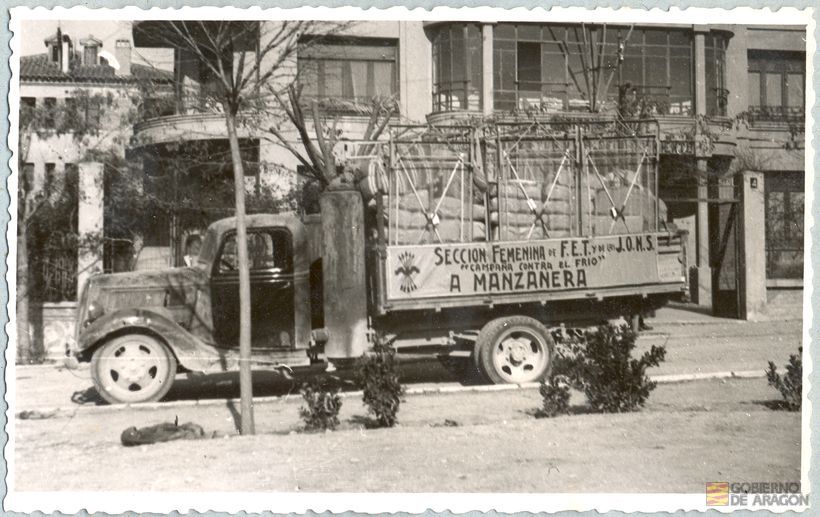 Divulgación y Asistencia. "Campaña de invierno". Camión de transporte "campaña contra el frío", estacionado en la puerta del chalet habilitado como Gobierno Civil en el nº 4 de la calle Fernando Hué del Ensanche, teniendo su destino a Manzanera. Teruel