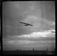 Avioneta en el cielo y personas en tierra. Mariano Gómez Zamora
