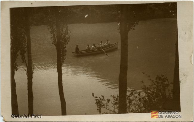 Barca de remos, con cinco personas navegando por un río. Gabriel Faci Abad