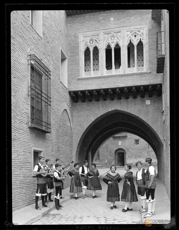 Retrato en plano entero de un grupo de joteros con traje regional en el Arco de Dean de Zaragoza