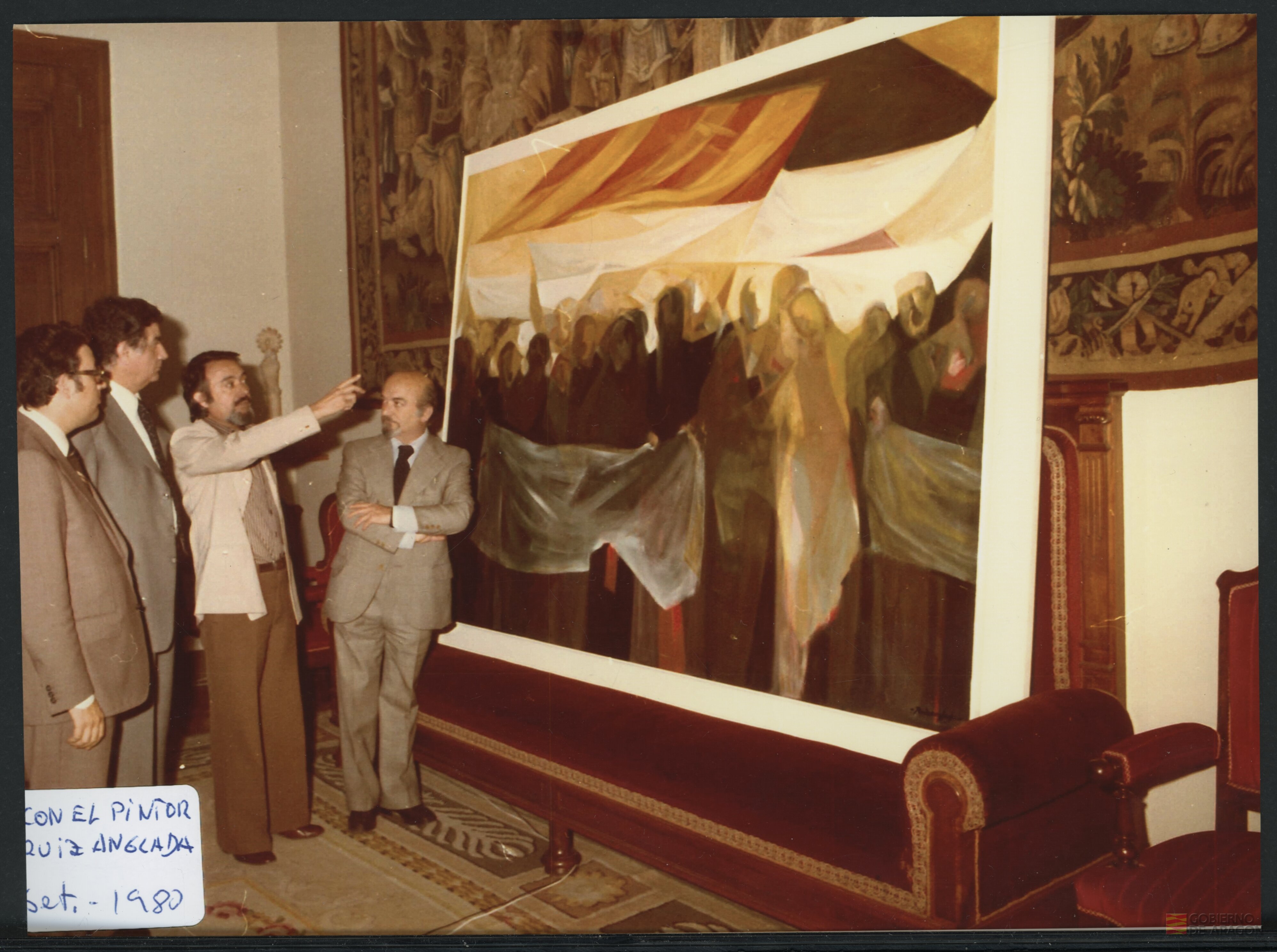 El pintor Ruiz Anglada mostrando un cuadro a los responsables de la Diputación General de Aragón