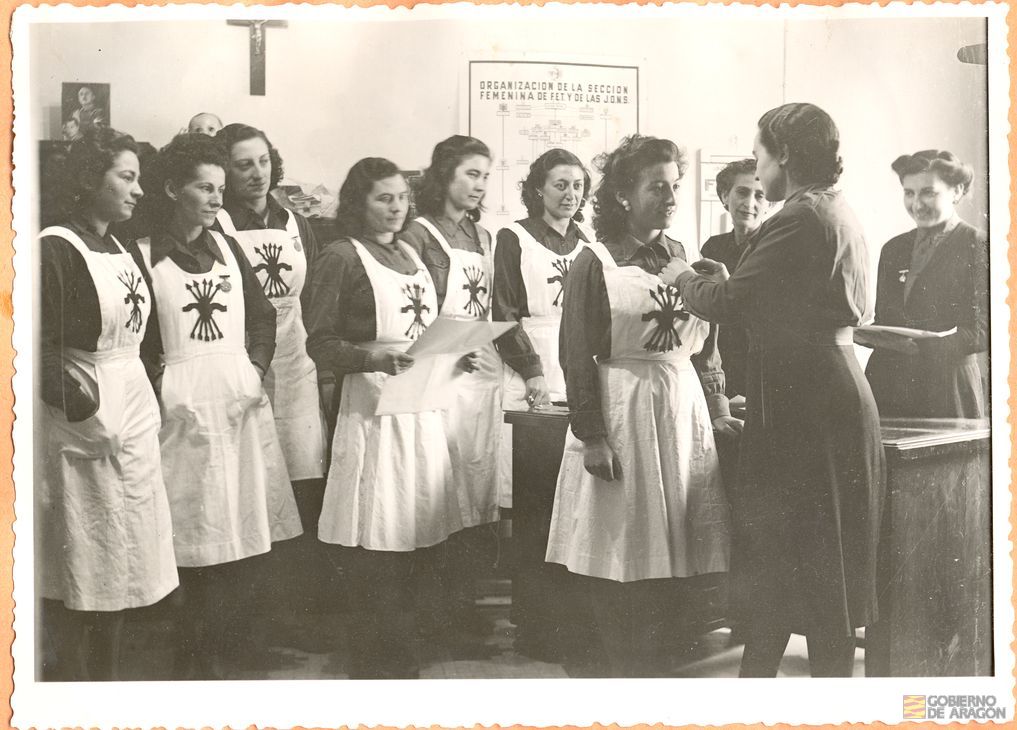 Servicio Social. Curso de divulgadoras socio-sanitarias. La Delegada Provincial de Sección Femenina Rita Navarro Mínguez, acompañada de las regidoras entrega las insignias y titulaciones a las cursillistas en la Delegación Local Escuela Hogar, plaza de la Marquesa, 29 de febrero. Miñana. Teruel