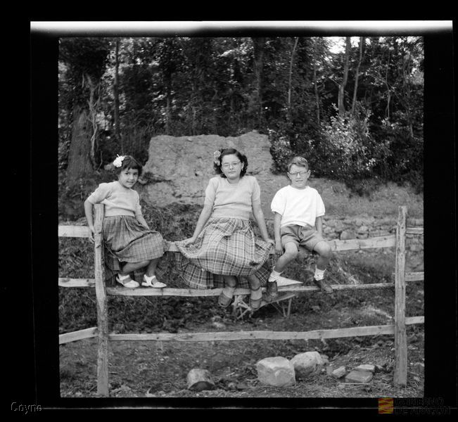 Retrato de tres niños sobre una valla. Manuel Coyne