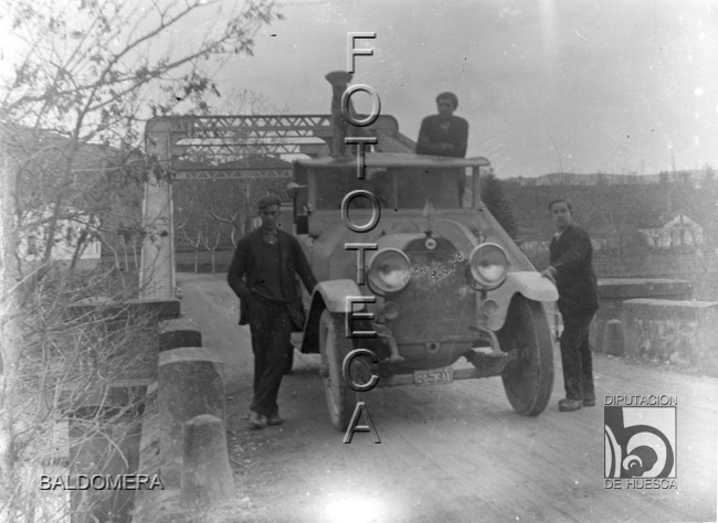 Hombres y perro posando con un camión a la salida de un puente. Antonio López Santolaria