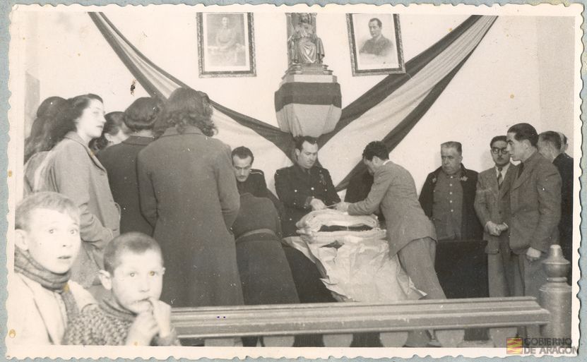 Divulgación y Asistencia. Campaña de invierno. Salón de actos y plenos del Ayuntamiento de Alcañiz, entrega de paquetes de ayuda a familias necesitadas. Preside el acto Francisco Labadíe Otermín, gobernador civil de la provincia. Alcañiz