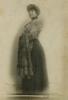 Mujer de pie sujetando varias pieles