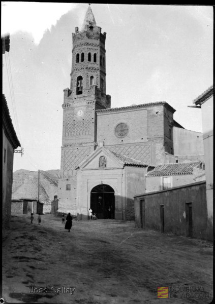 Alfajarín (Zaragoza). Iglesia parroquial. Torre mudéjar. Casas y grupo de gente. José Galiay Sarañana