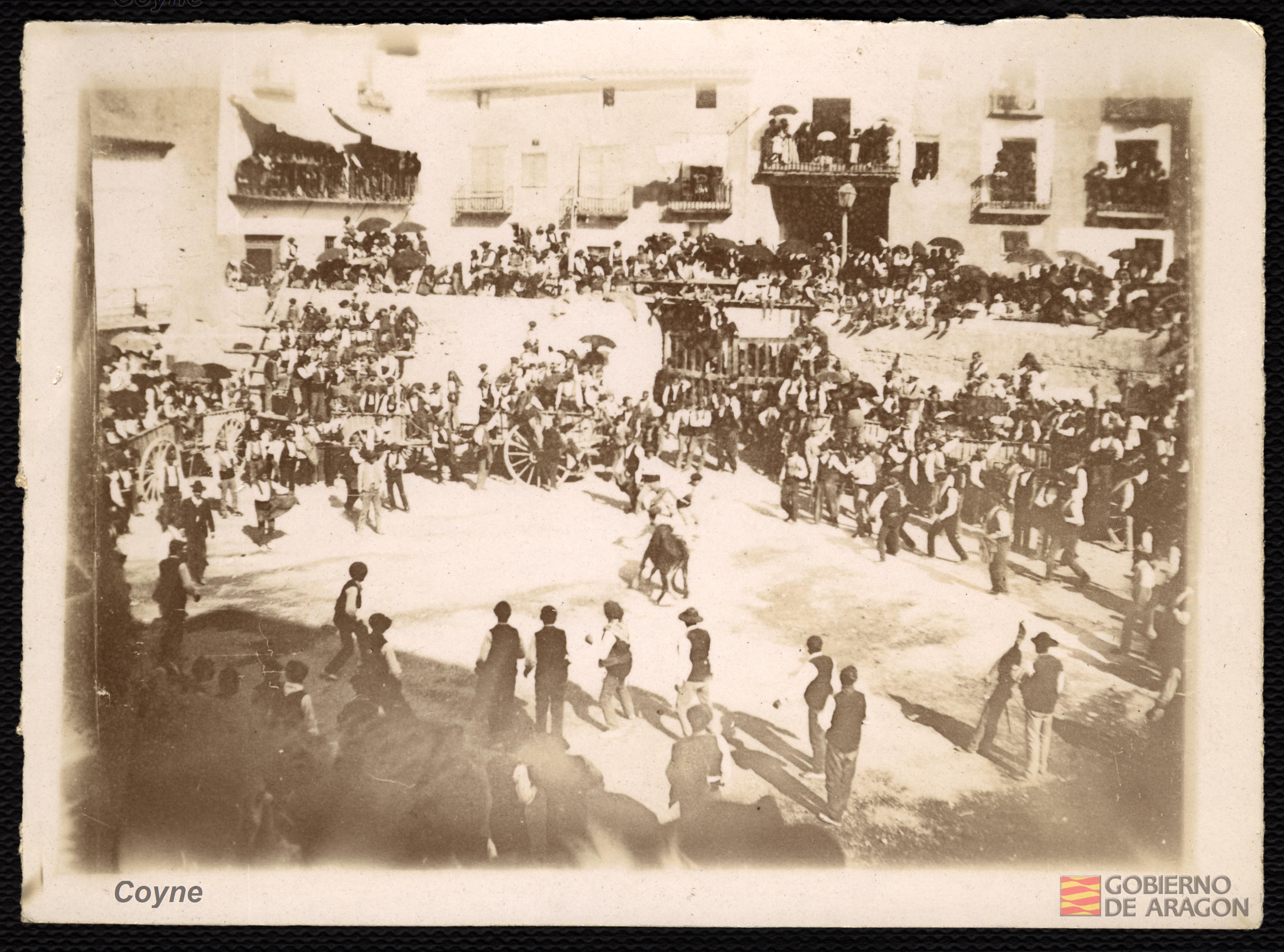 Corrida de toros o de vaquillas en la plaza de un pueblo. Mozos. Carros y carretas