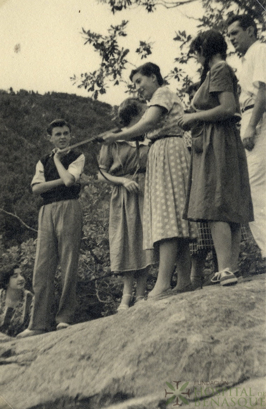 Mujer apuntando con una escopeta acompañada de varias personas