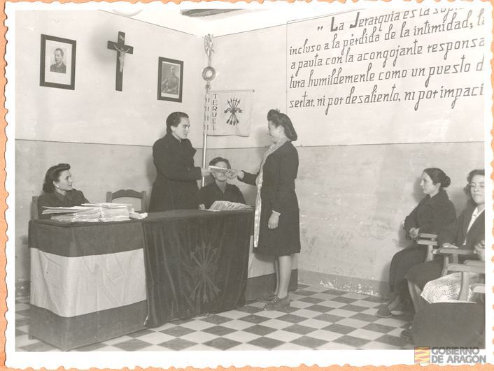 Servicio Social para la Mujer. Entrega de certificados a las cumplidoras del Servicio Social para la Mujer por Rita Navarro Mínguez, delegada provincial de la Sección Femenina en locales de la Delegación Local Escuela Hogar. Teruel