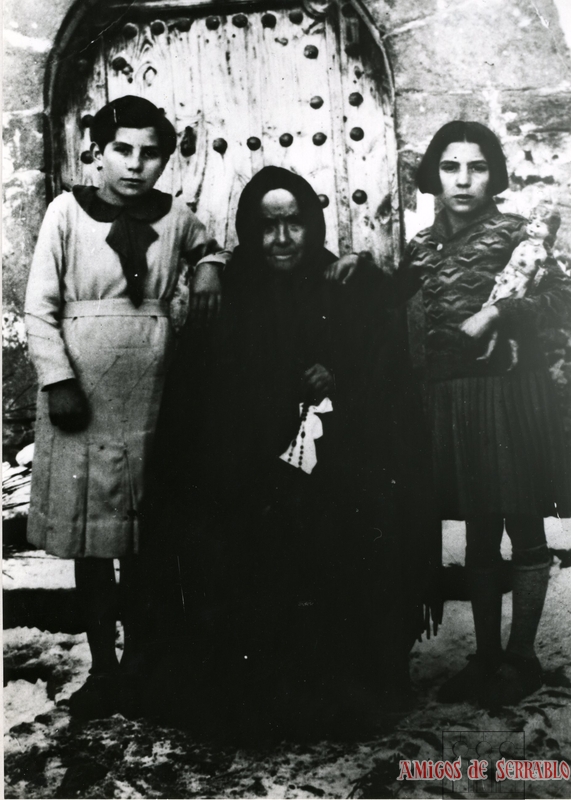 Mujer y niñas en la puerta de la iglesia de Gésera