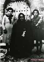 Mujer y niñas en la puerta de la iglesia de Gésera