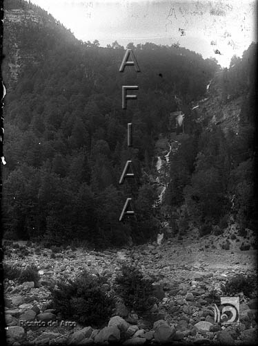 Lecho pedregoso de un río y cascada. Ricardo del Arco y Garay