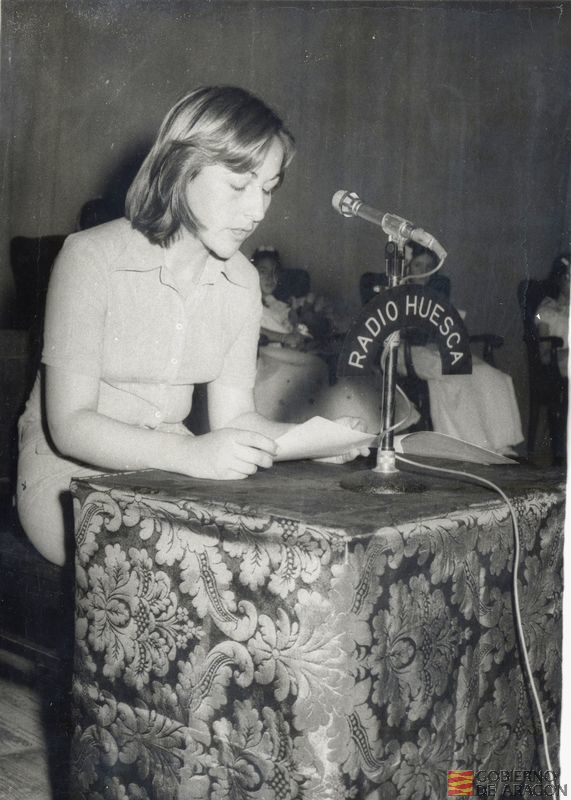 Niña leyendo para la emisora de Radio Huesca