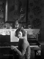 Mujer joven sentada delante de un piano. Ricardo del Arco y Garay