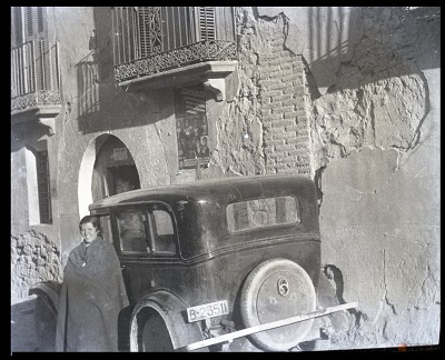 Carmen posando ante un automóvil delante de una casa