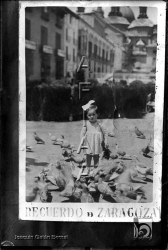 Niña con lazo rodeada de palomas. Joaquín Galán Bernal. Zaragoza