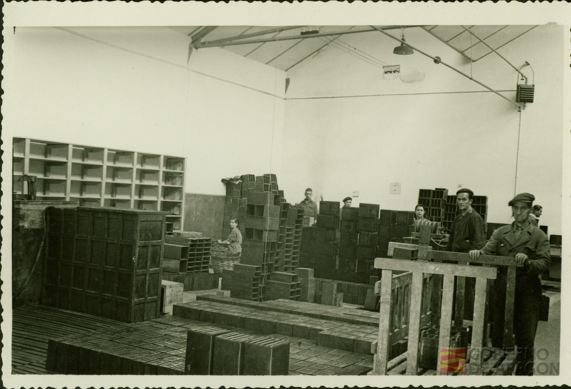 Trabajadores, hombres y mujeres, apilan y colocan materiales en una nave de la fábrica Tudor de Zaragoza